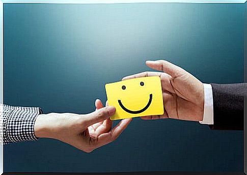 Businessman and client holding note with a smiley face symbolizing how to improve your Emotional Intelligence.