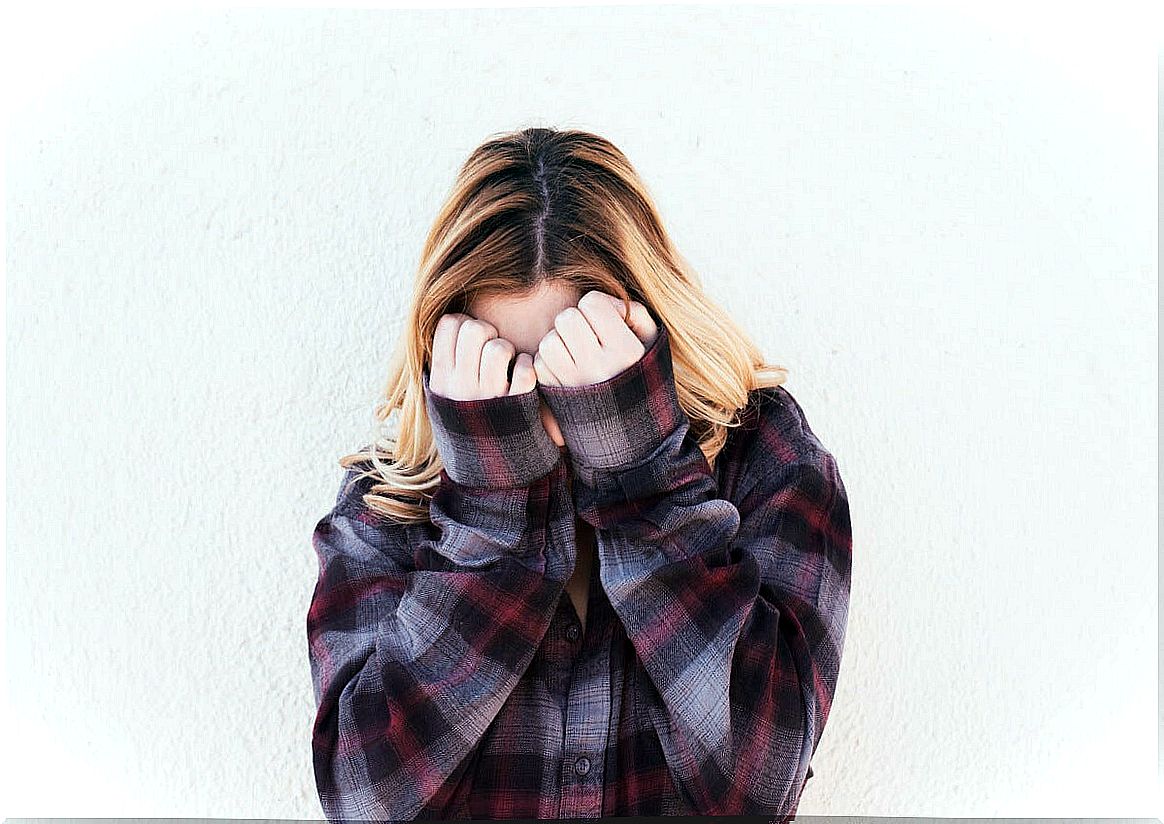 Teenage girl covering her face out of shame