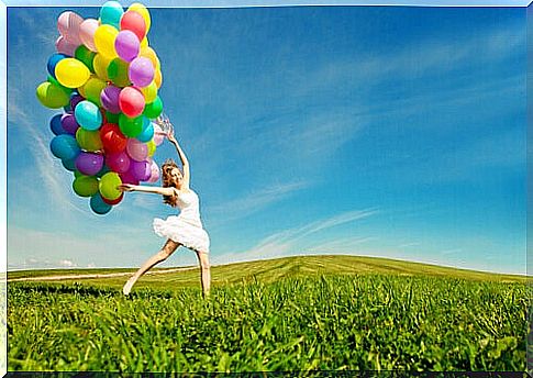 Woman with colorful balloons in the field