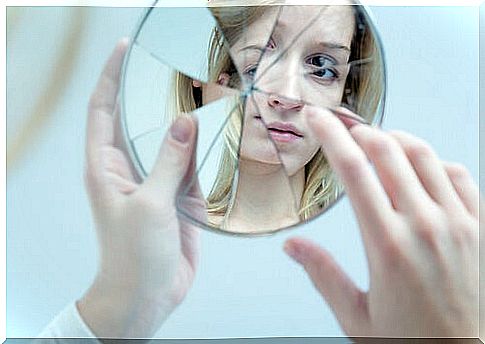 Teen girl looking in the mirror trying to recover from emotional abuse