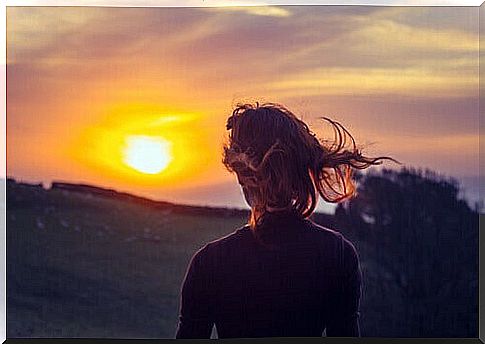 Woman watching the sunset while thinking about the benefits of a withdrawal on time