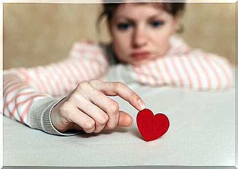 Sad woman touching a heart representing magnetic minds