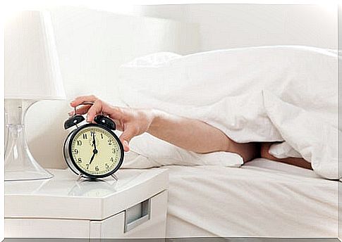 Man turning off alarm clock